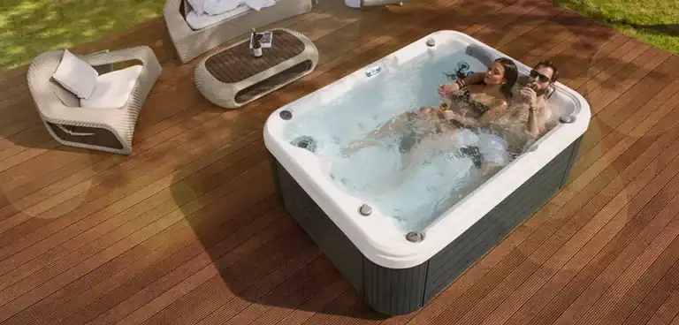 Couple relaxing in one of the best small hot tubs in a compact backyard