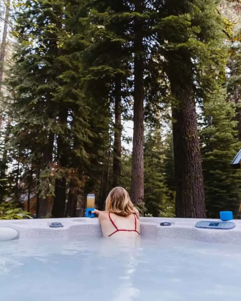 Woman soaking in an outdoor hot tub with slightly cloudy pale blue water