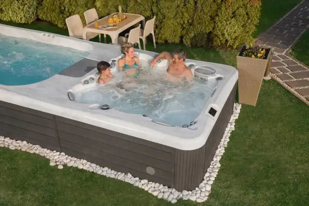 Family enjoying a swim spa together in the backyard