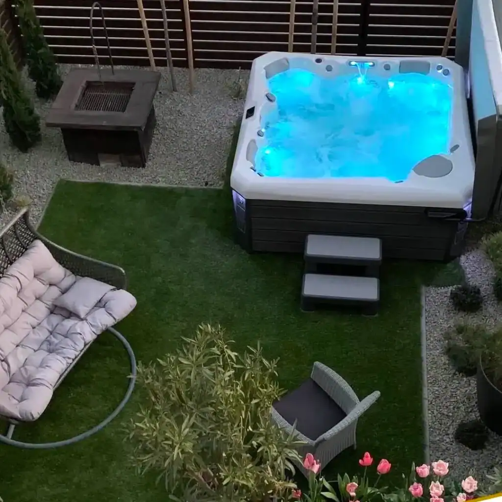 Backyard hot tub at night with the cover off, the most common cause of a hot tub losing water through evaporation