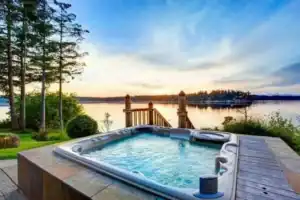 Hot tub placement on a lakeside patio at sunset