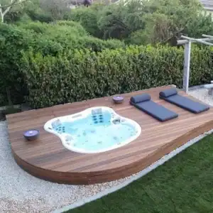 In ground hot tub set into a low deck with loungers