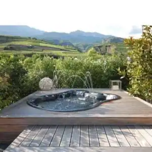 In ground hot tub placement with fountain jets and a mountain view