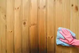Cleaning a home sauna bench during routine maintenance