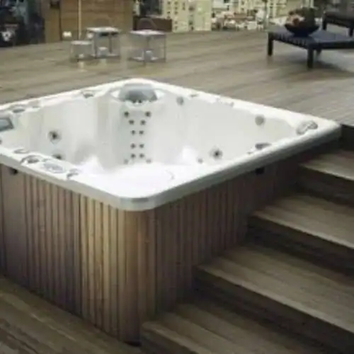 Split level hot tub installation half recessed into a deck with steps