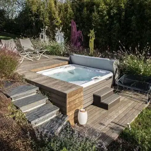 Split level hot tub installation set into a garden slope with stone steps