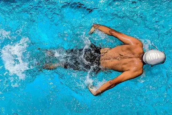 Swimmer exercising against the current, the main fitness advantage of a swim spa vs hot tub