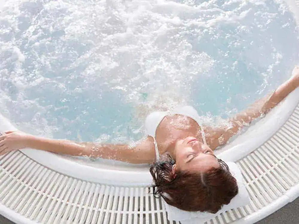 Woman relaxing in a warm hot tub soak to relieve sore muscles