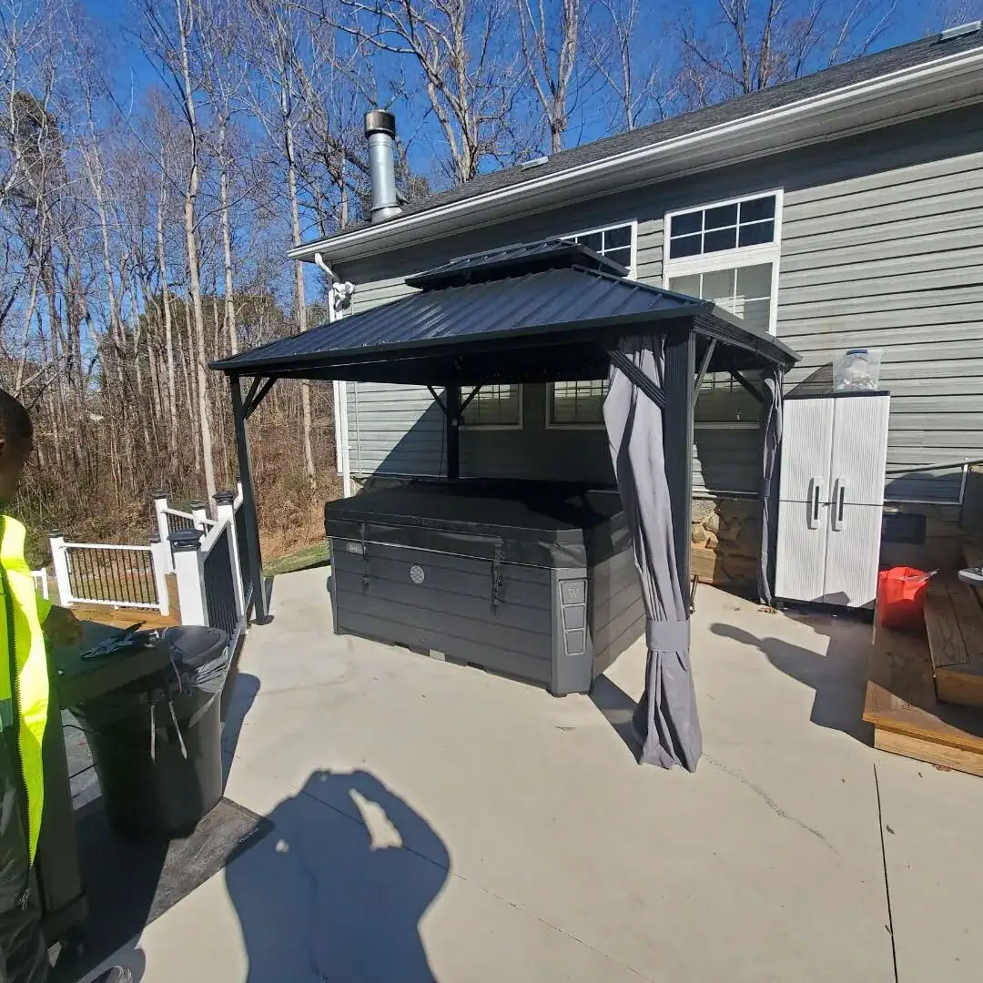 Covered hot tub on a concrete pad under a gazebo after delivery